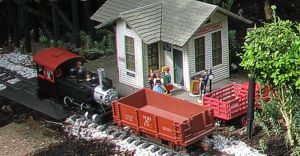A Bachmann Big Hauler 0-4-0 with the improved metal running pushing three cars with Aristo couplers past Donnels Creek station.  Click for bigger photo.