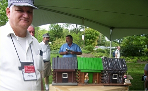 Mike displaying houses he had made from a $5 Michaels log cabin. Click for bigger photo.