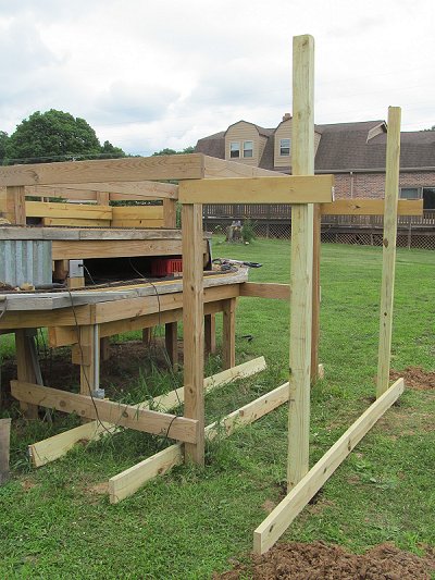 The 10' posts are dropped into the 2' holes and scrap lumber has been screwd on temporarily to keep them vertical.  Click for bigger photo.