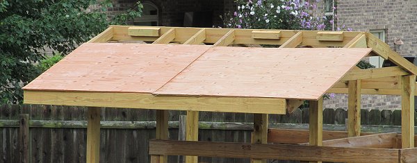 The first two pieces of sheathing, before I trimed the edges over the eaves and rakes (gables). Click for bigger photo.