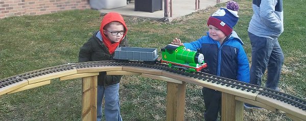 Two youngsters checking out Percy and one of the Troublesome Trucks on a temporary raised railroad.  Click for bigger photo.