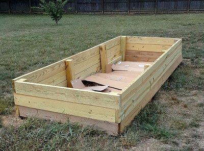 This raised garden bed will give me some place to put the dirt from the hole for the pond. The cardboard in the bottom is to discourage weeds in the ground from growing up through the 'new' dirt. Click for bigger photo.