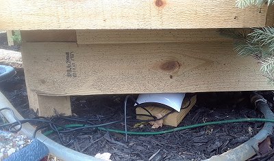 The AirPod air pump tucked under two layers of railroad to protect it from direct rain or snowfall. I may move it into the train shed before long. Click for bigger photo.