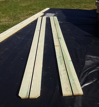 These 8' pressure-treated fence boards slit in half will edge the platform, providing a more finished look and holding dirt and gravel in place. Click for bigger photo.
