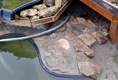 The next stretch of rocks included a large limestone chunk from our back yard.  In this photo, the stones have been set in sand mix, dusted with sand mix to create 'mortar lines,' soaked down, and the tops rinsed off. (There is still water standing in places. Click for bigger photo.
