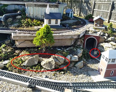 Four of the dozen or so rocks that the raccoon has pulled out of place looking for snacks.  Now when I'm going to run my trains, I have to make certain there aren't any boulders on the track.  Click for bigger photo.