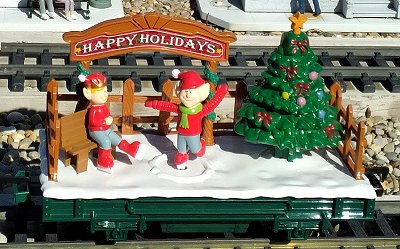 The elf skating car is less common, but usually not hard to find. Some versions include a pair of elf carolers in front of the Christmas tree.  Click for bigger photo.